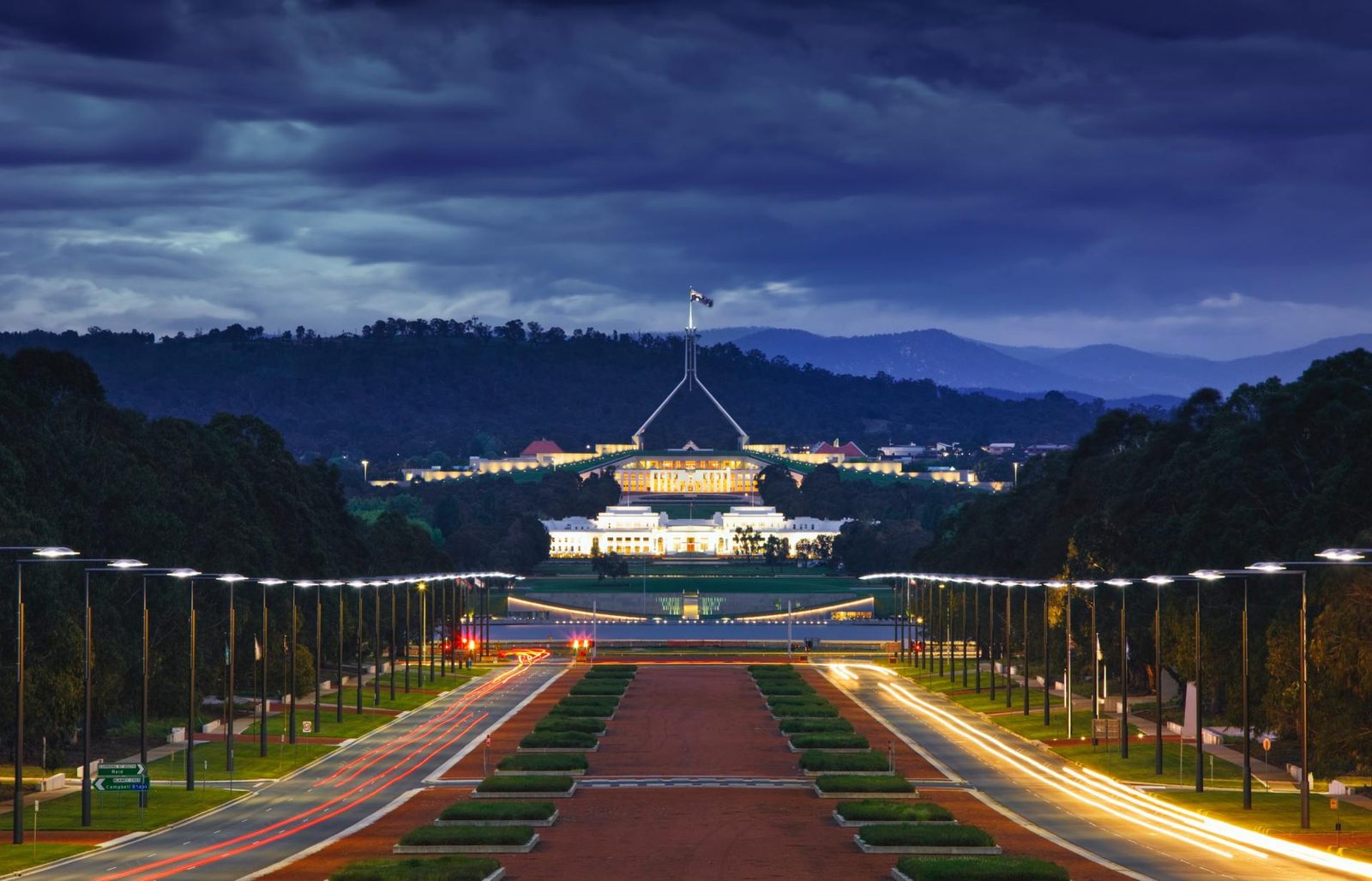 The australian parliament building is lit up at night