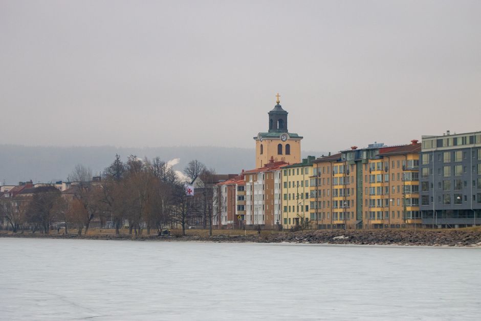 A serene winter view of Jönköping's lakeside with colorful buildings and a historic church.