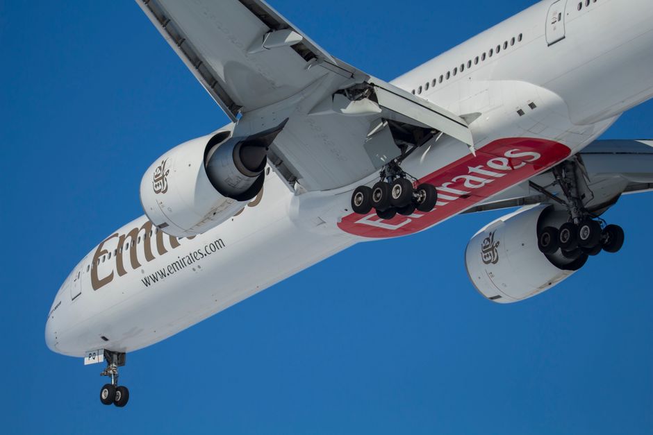 A large passenger aircraft flying against a clear blue sky during daytime.