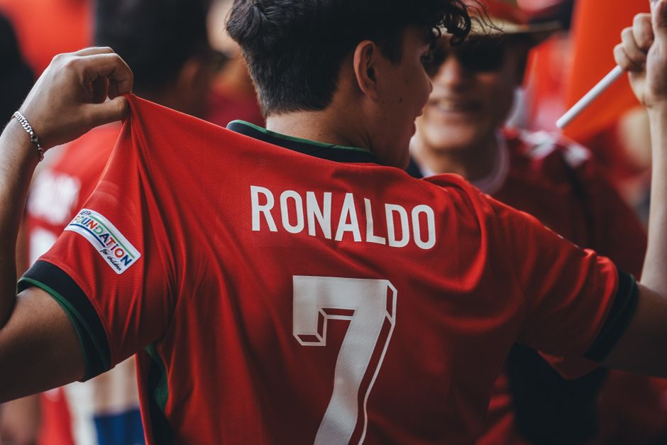 A passionate soccer fan wearing a Ronaldo jersey celebrates at a sports event.
