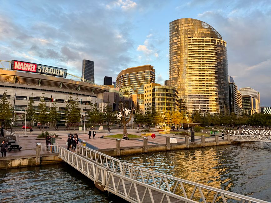 Captivating view of Marvel Stadium and Docklands, Melbourne at sunset. Lively waterfront scene.
