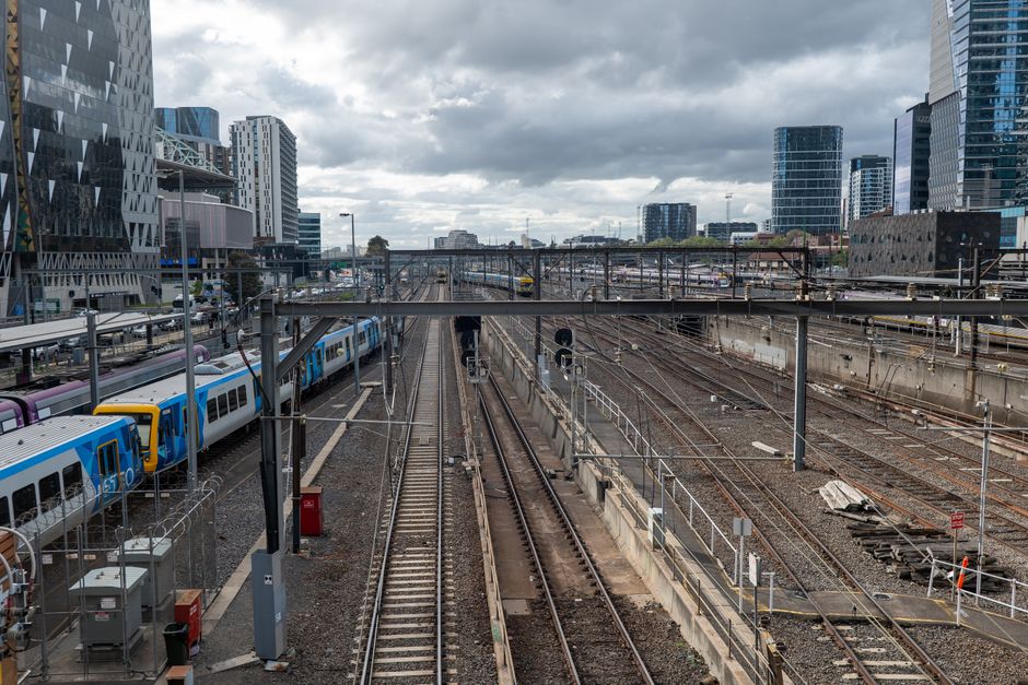 Aerial view of train tracks and buildings in Docklands, Melbourne, showcasing urban modernity and transit.