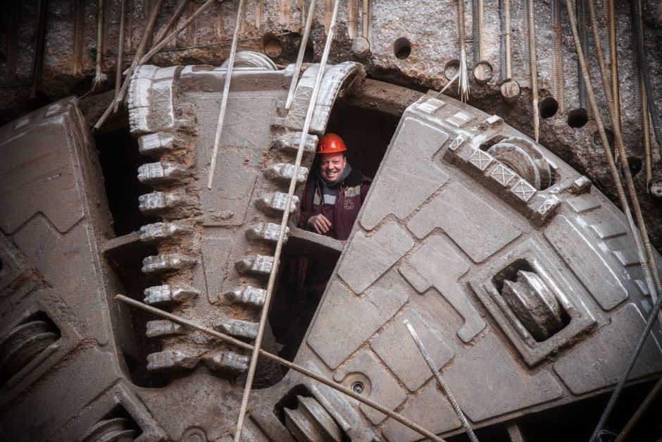 Construction worker stands inside massive tunneling machine in Moscow, Russia, showcasing industrial capability.